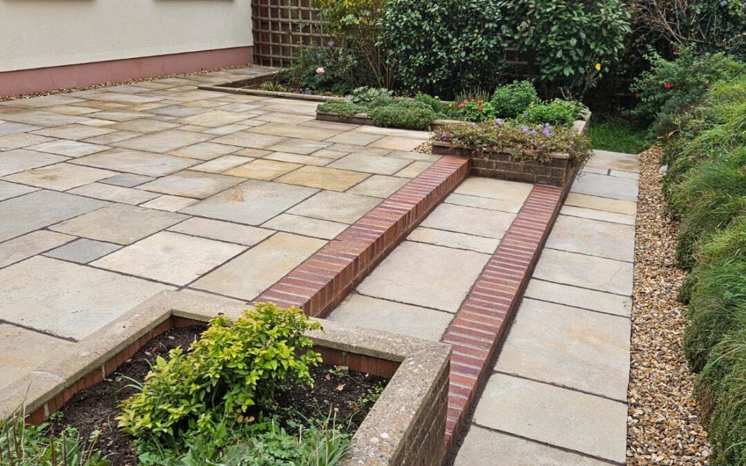 beige paving in back garden with red brick edging