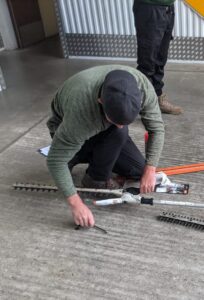 Man wearing cap maintaining garden equipment